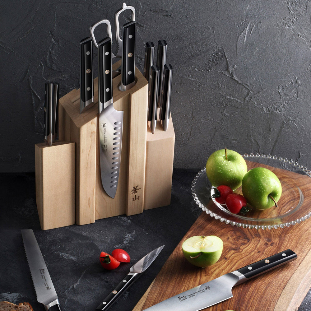 
                  
                    Load image into Gallery viewer, Set of knives in a wooden block on a dark surface with a cutting board and apples.
                  
                