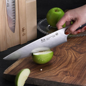 
                  
                    Load image into Gallery viewer, Person cutting an apple with a chef&amp;#39;s knife on a wooden cutting board.
                  
                